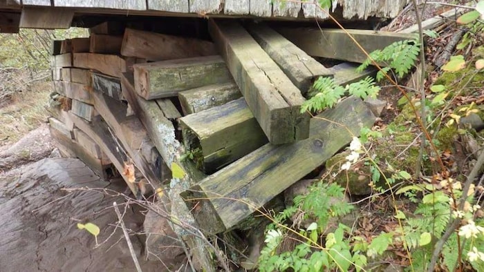 Un assemblage de poutres sous une extrémité du pont est en mauvais état.