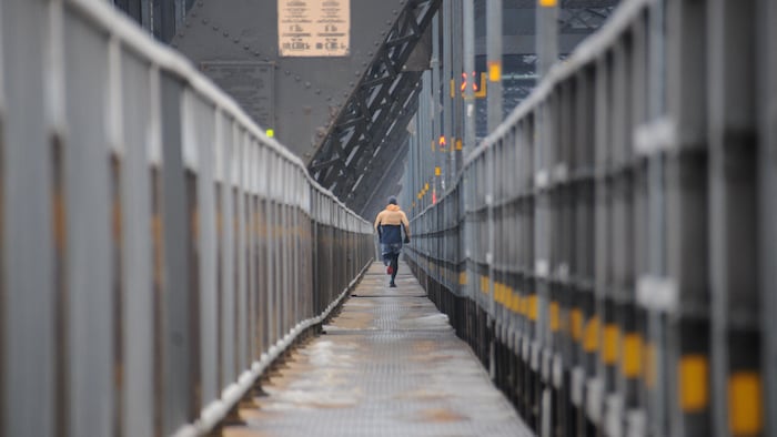 Un coureur emprunte le pont de Québec en hiver.