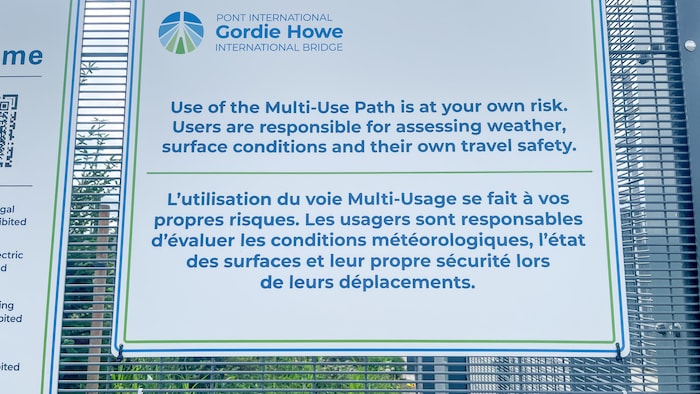 Panneau à l'entrée de la voie côté Canada, indiquant que l'utilisation de la voie se fait à vos propres risques, avec une faute de français.
