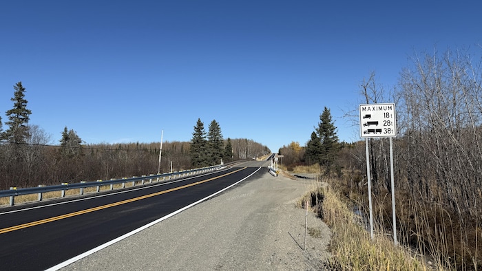 Un pont avec un panneau de limitation de poids. 
