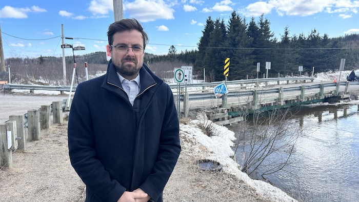 Un homme se tient devant un pont fermé.