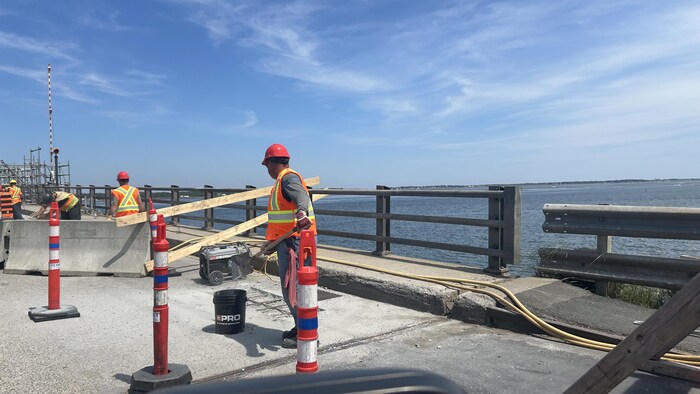 Des ouvriers travaillent sur un pont.
