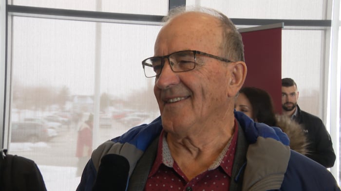 Jules Haché s'exprime au micro d'un journaliste. 