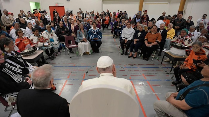 Pope Francis faces dozens of people sitting down.