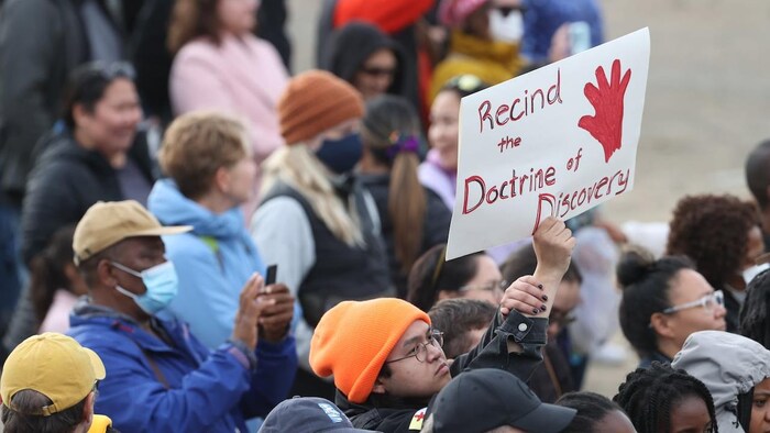 A person holds a protest sign.