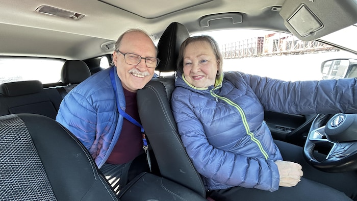 Un couple de bénévoles dans une voiture.
