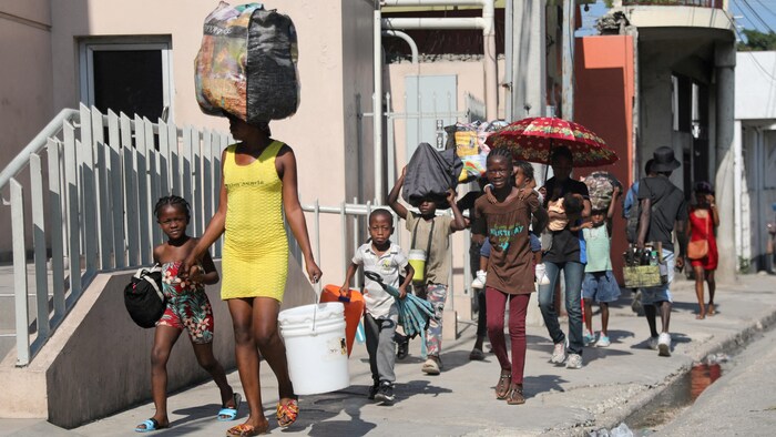 Des familles marchent à Port-au-Prince le 9 mars 2024.