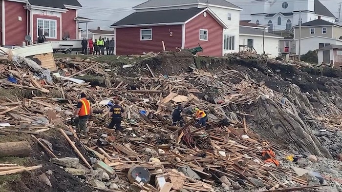 عمال الإنقاذ يبحثون عن امرأة مفقودة في حطام منزل في مدينة تشانل بورت أو باسك في أقصى جنوب غرب جزيرة نيوفاوندلاند بعد مرور عاصفة ’’فيونا‘‘.