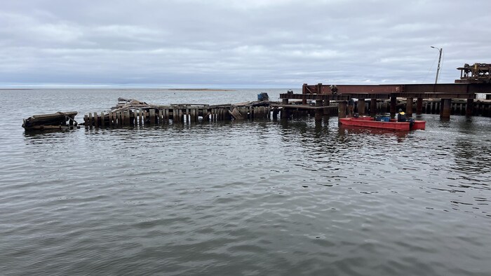 Les restes de la digue du port de pêche d'Abram-Village flottent sur l'eau.