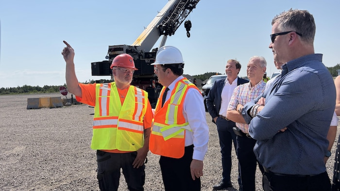 Des hommes discutent devant une grue.