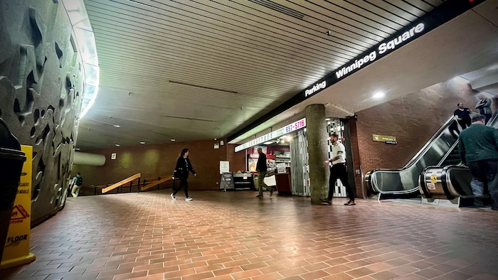 Des personnes marchent dans le tunnel sous Portage et Main. 