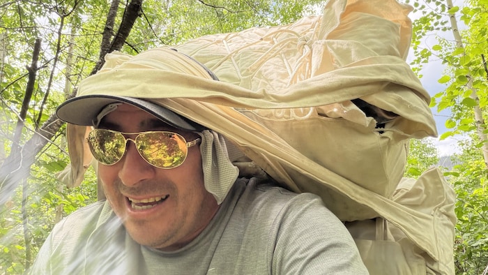 Le chef innu porte ses bagages attachés sur sa tête.