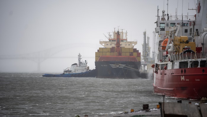 Un porte-conteneur et un bateau remorqueur au port de Trois-Rivières.
