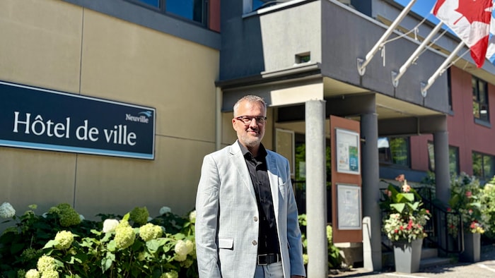 Simon Sheehy se tient devant l'hôtel de ville de Neuville.