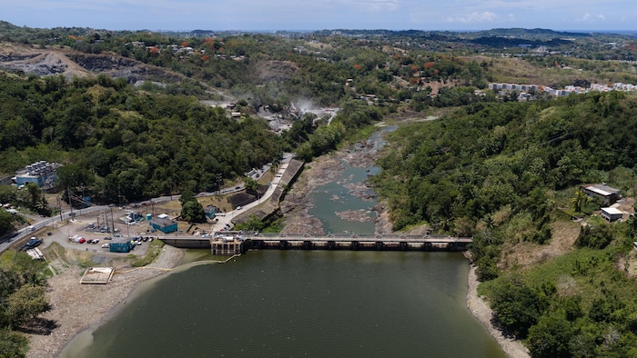 Photo aérienne du barrage et de son réservoir. Dans la partie en amont, le niveau de l'eau est très bas, comme en témoignent des roches qui apparaissent à la surface.