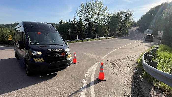 Des véhicules de police surveillent un périmètre.