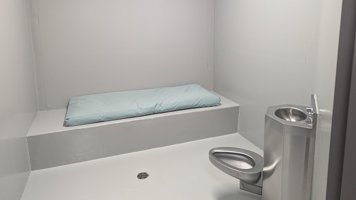 Une cellule avec le strict minimum, soit un matelas, un lavabo et une toilette en acier inoxydable.