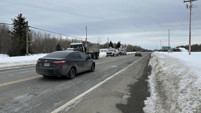 Des voitures passent près de camions de Cablevision sur la route 101.