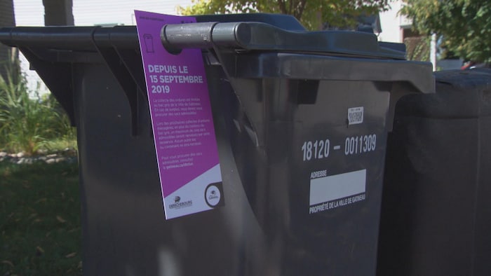 Un bac de poubelles, avec un avertissement fourni par la Ville de Gatineau.