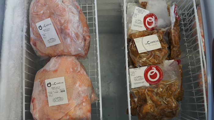 Des deux poulets entiers congelés dans un congélateur.