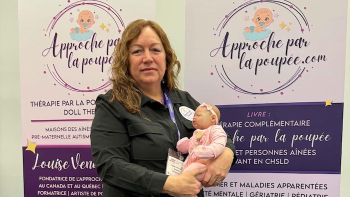 Louise Vendette pose avec une poupée reborn.