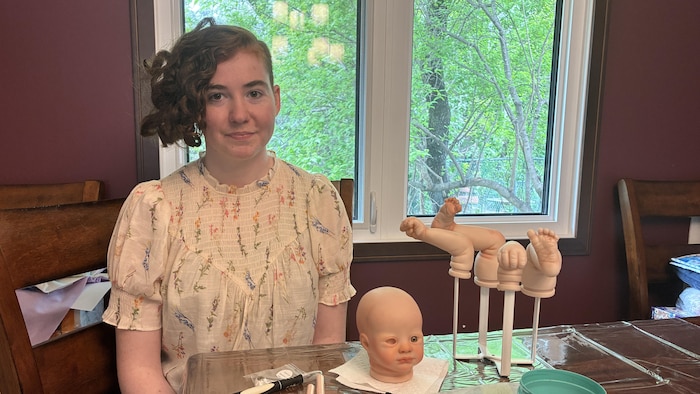 L'artiste reborn Danica Grégoire pose avec son matériel.