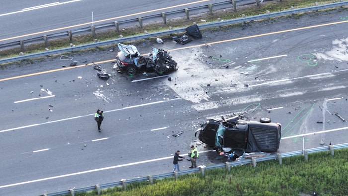Deux véhicules endommagés sur la route, vus de haut.