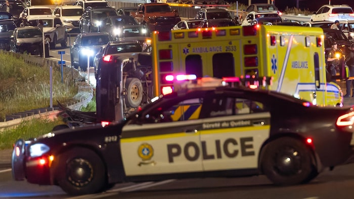 Des voitures de police et une ambulance bloquent la circulation sur le pont.