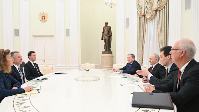 Des hommes et une femme assis autour d'une table.