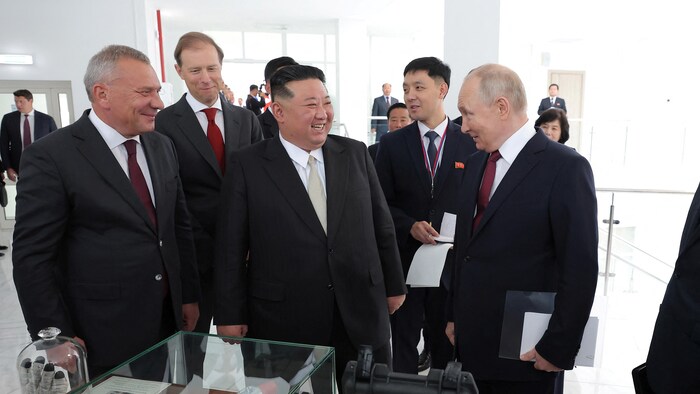 Vladimir Poutine et Kim Kong-un entourés de dignitaires lors d'une visite.