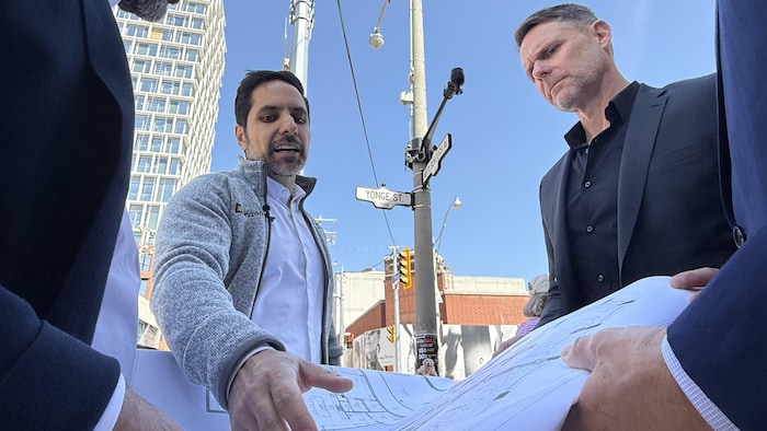 Pouyan Safapour et un autre homme examinent des plans d’architecte d’un immeuble à condos.