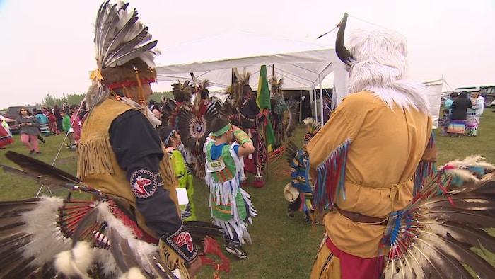 Des membres de la Première Nation crie James Smith portant des regalia lors d'un pow-wow, le 25 mai 2023.