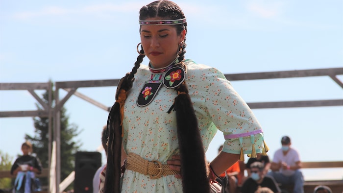 Une femme en costume traditionnel danse.