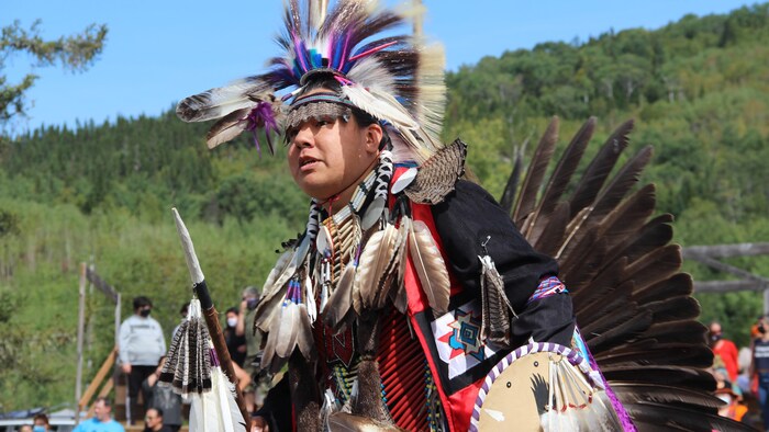 Un homme porte un costume traditionnel autochtone orné de plumes.