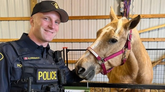 Le constable Grzegorz Pierzchala pose avec un cheval.