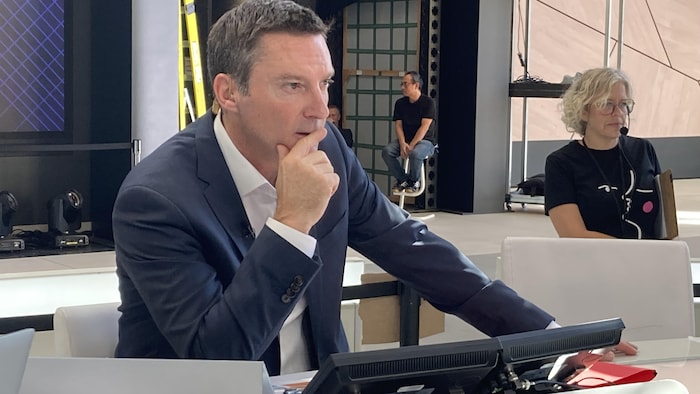 Patric Roy est assis au pupitre, devant la caméra.