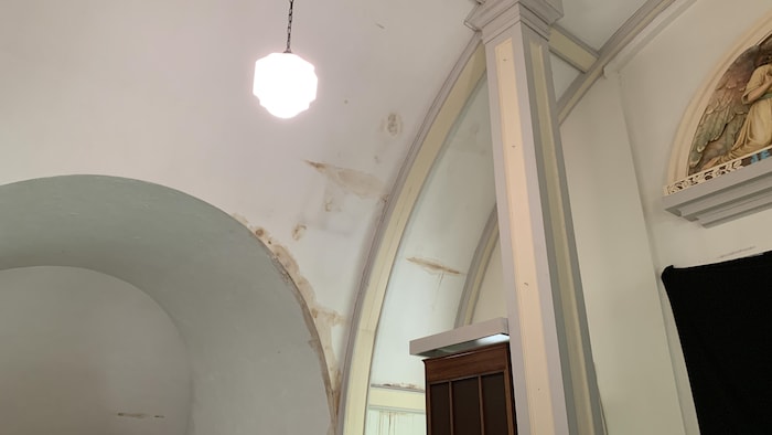 Des traces de moisissure au plafond couleur crème d'un bâtiment au toit en voûte.