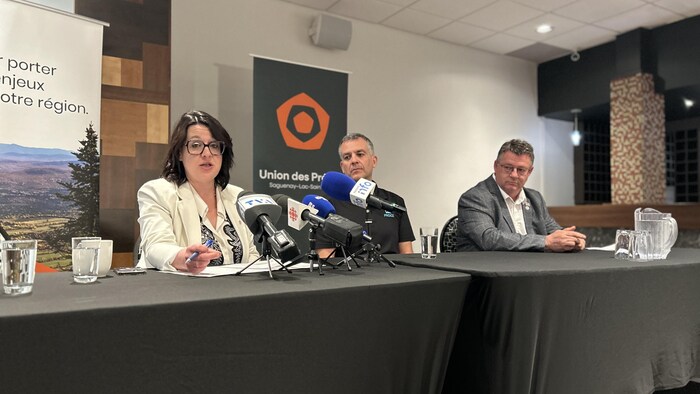 Trois personnes assises à une table. 