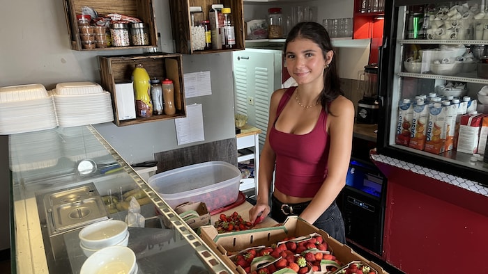 Ariane sourit devant la caméra en coupant des fraises.