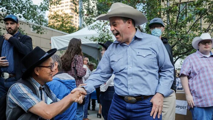 El primer ministro de la provincia de Alberta, el conservador Jason Kenney, saluda a una persona dando la mano.