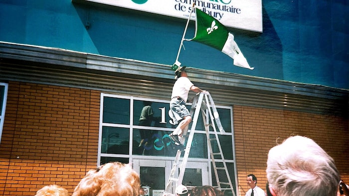 Cérémonie de lever du drapeau vert et blanc devant le Centre de santé communautaire en 2003.
