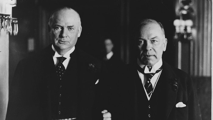 Richard Bedford Bennett holds the arm of William Lyon Mackenzie King in an archive photo.
