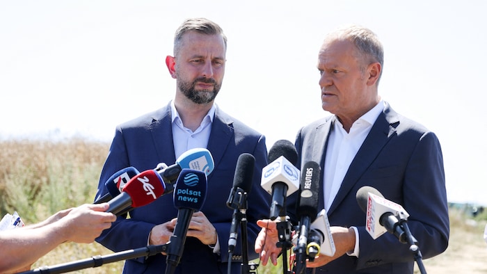 Le premier ministre polonais Donald Tusk s'adresse à la presse, en compagnie du ministre de la Défense Wladyslaw Kosiniak-Kamysz, le 30 juillet 2026, près du village de Tarnawa-Kolonia, en Pologne.