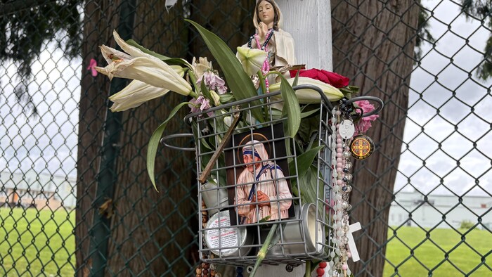 On voit une des fleurs, l'image d'un saint, et une sculpture de Marie.