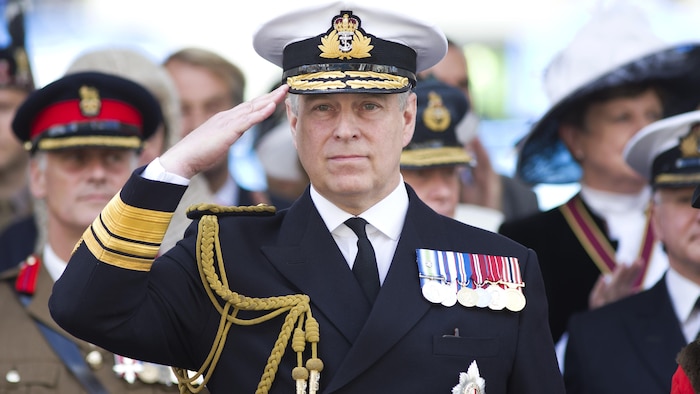 Le prince Andrew, en uniforme, fait un salut militaire.