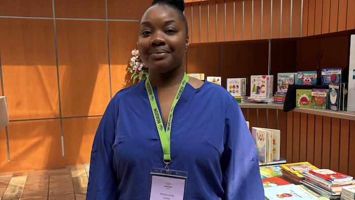 Prisca Lonzy devant des livres.