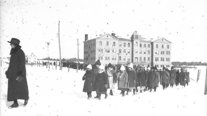 De jeunes élèves en manteaux.