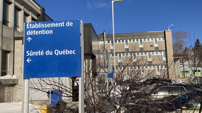Une pancarte indiquant la prison et le poste de police de la Sûreté du Québec. On voit derrière l'établissement correctionnel.