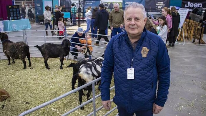 Tim Rowan est debout devant un enclos d'animaux alors qu'on aperçoit des gens autour.