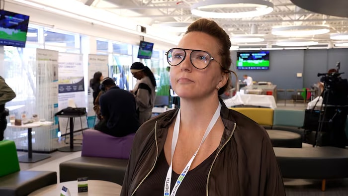 Marla Tremblay dans une salle où l'on voit d'autres personnes derrière elle.